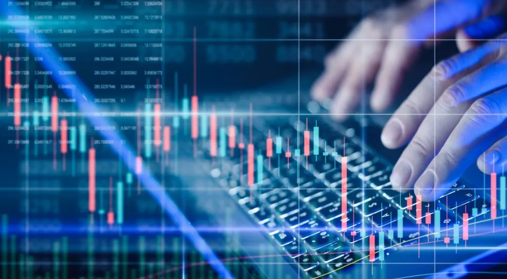 Main d’un trader sur clavier avec graphique boursier en surimpression, illustrant la manipulation de cours sur les marchés financiers